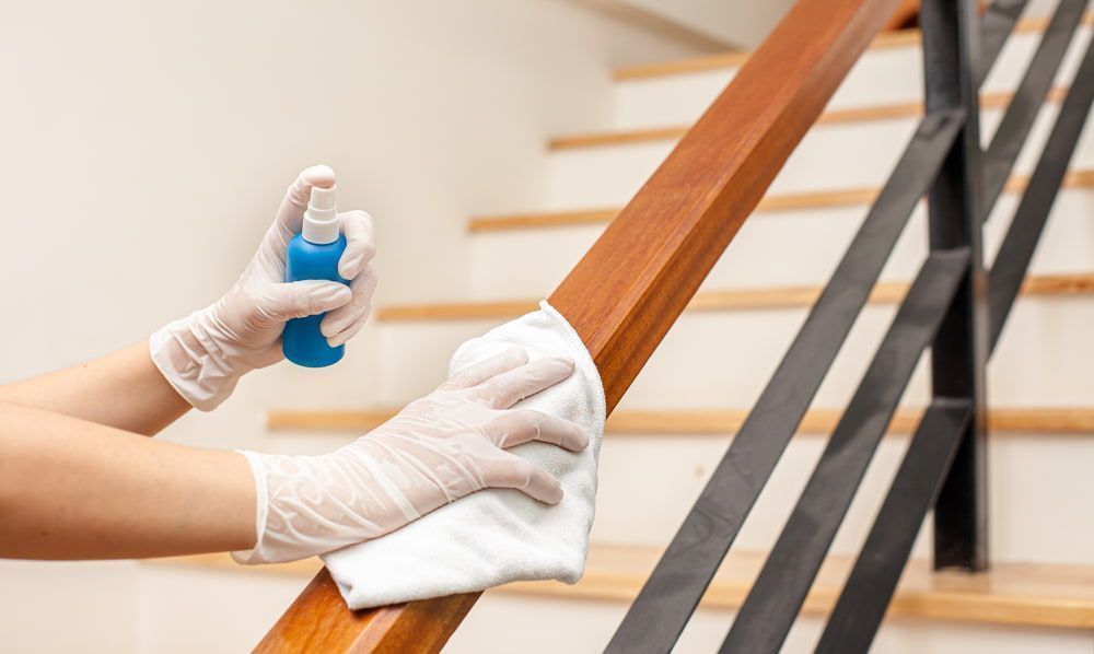 Person is Cleaning a Wooden Railing With a Cloth and Spray — Active Cleaning Service Rutherford, NSW