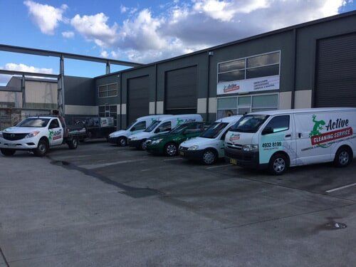 Row of Vans Parked in Front of a Building — Active Cleaning Service Rutherford, NSW