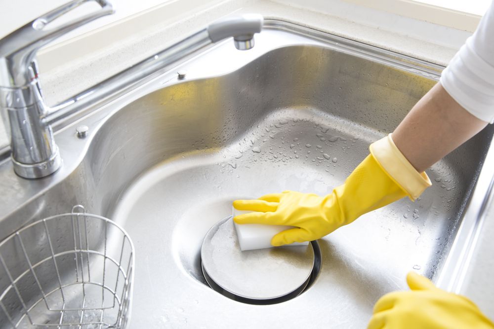 A Person Cleaning a Kitchen Sink