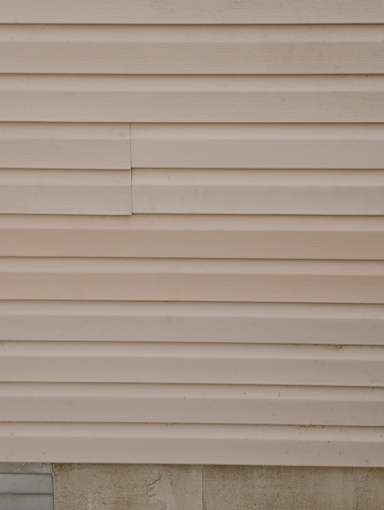 A close up of a beige siding on a house.