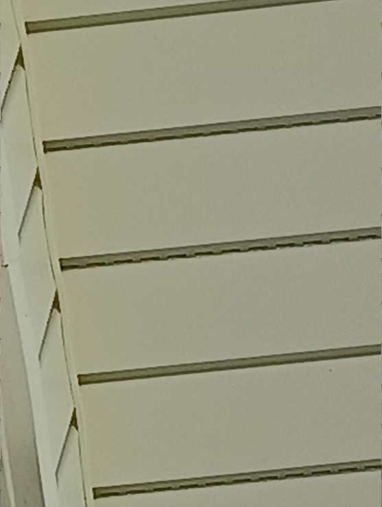 A close up of a white wall with slats on it