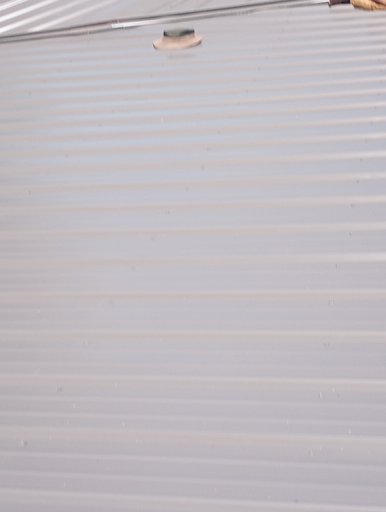 A close up of a gray roof with a hole in it.