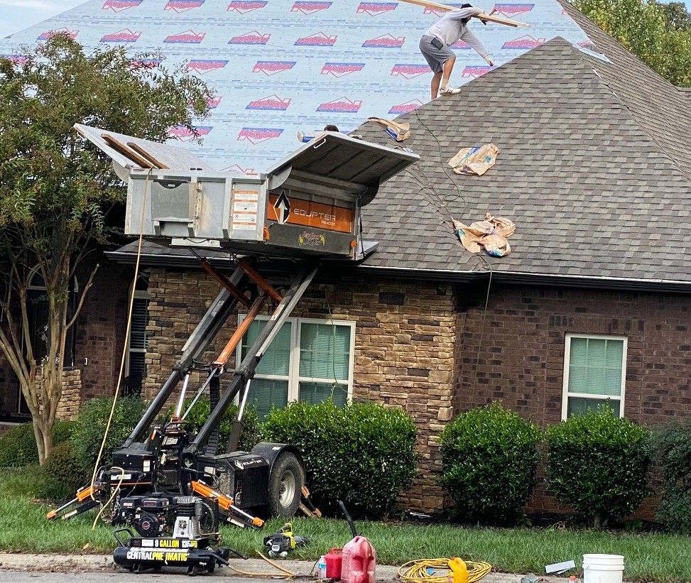 Worker installing asphalt shingles with a nail gun on a roof. Worker installing asphalt shingles with a nail gun on a roof.