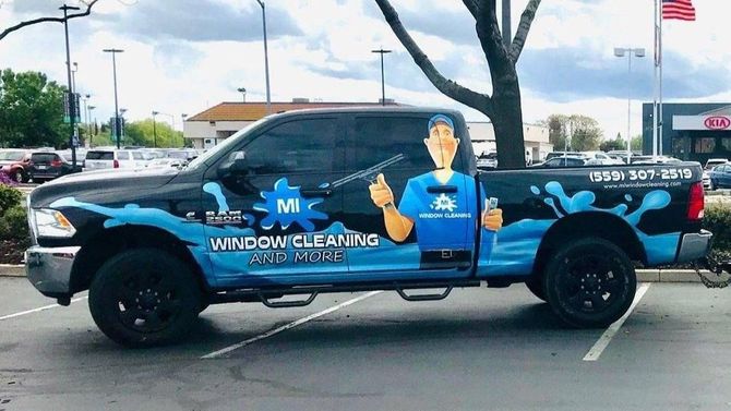 A window cleaning truck is parked in a parking lot