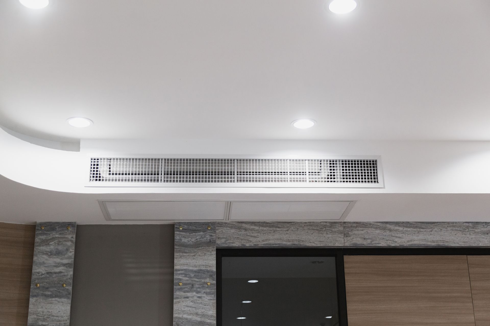 White Ceiling With Recessed Lighting and Air Vent Above a Dark Window
