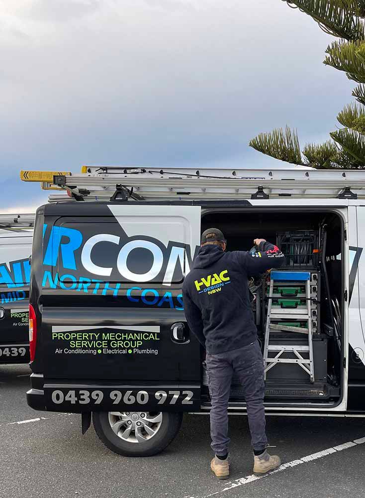 Man putting tools in the van — Air Conditioning Electricians in Forster NSW