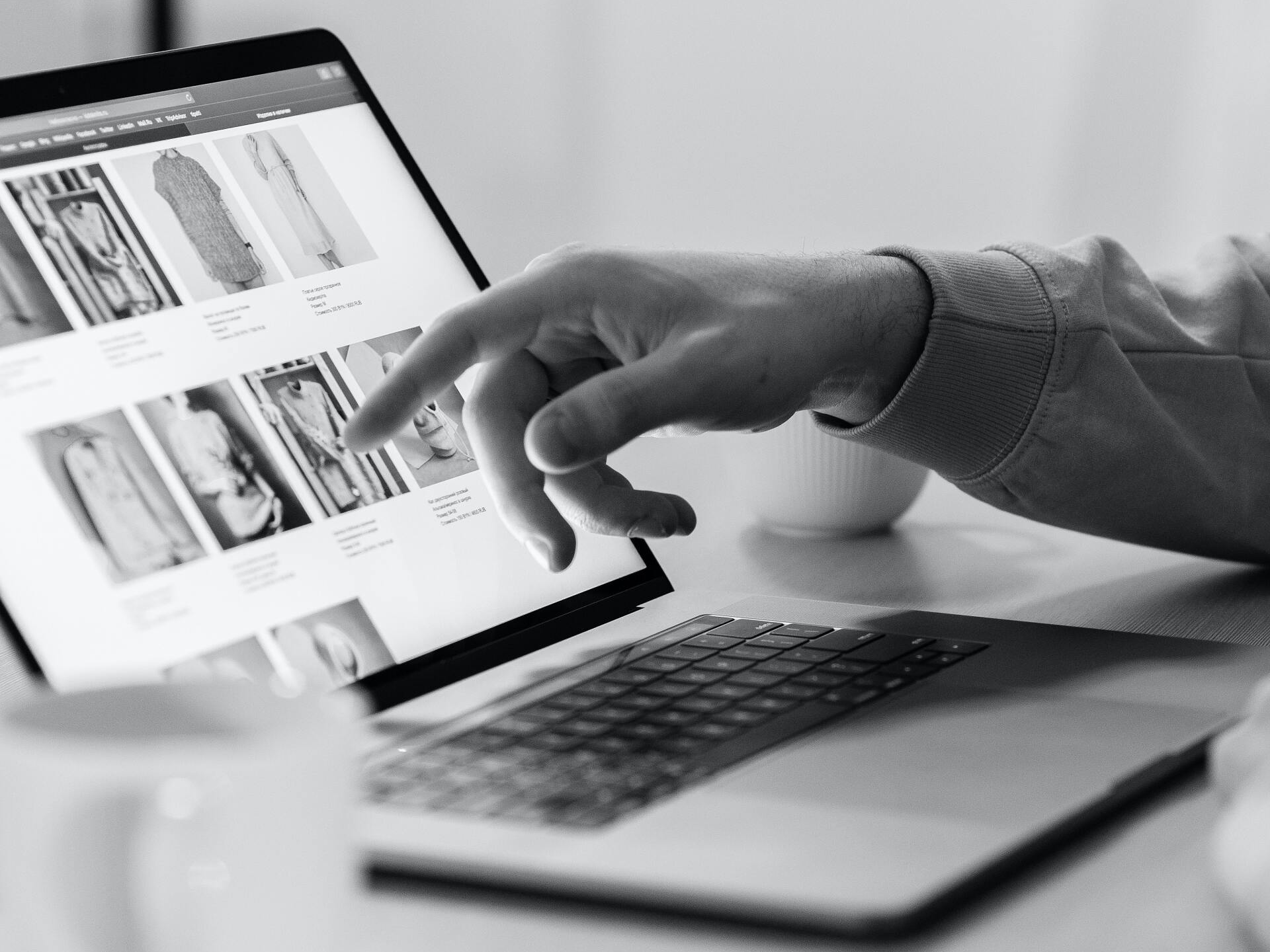 Ein Schwarzweißfoto einer Person, die einen Laptop benutzt.