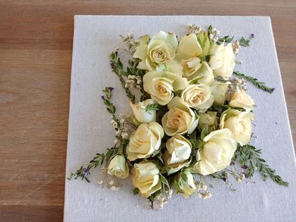Bouquet of cream roses with greenery on white lace fabric