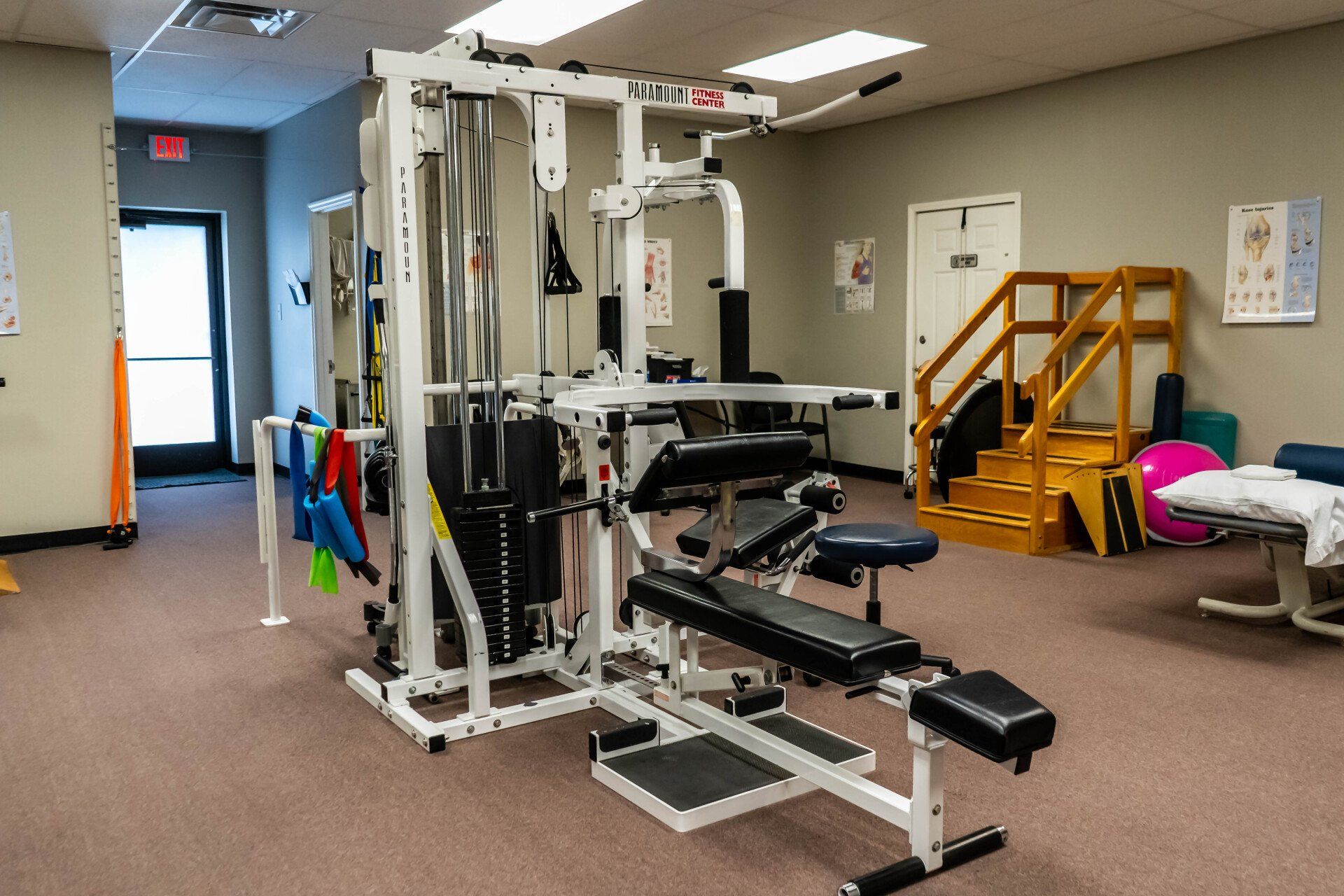 a gym with a lot of exercise equipment and a bench .