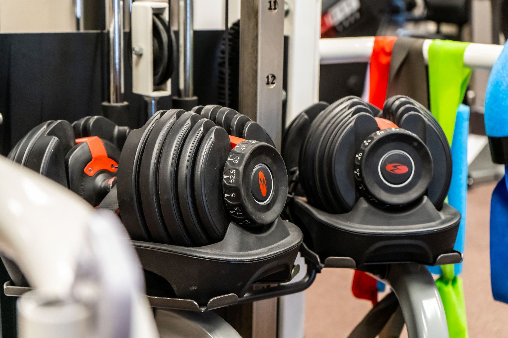 a pair of dumbbells sitting on top of a rack in a gym .