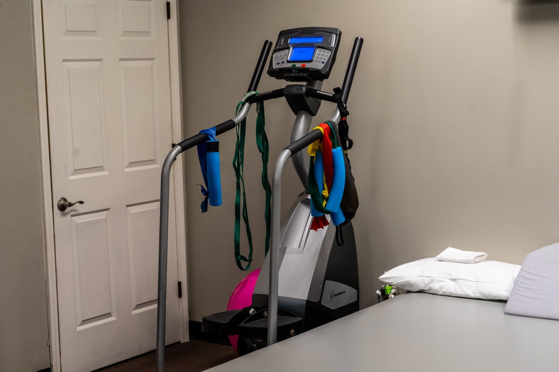 an elliptical machine is sitting on a table in a room next to a door .