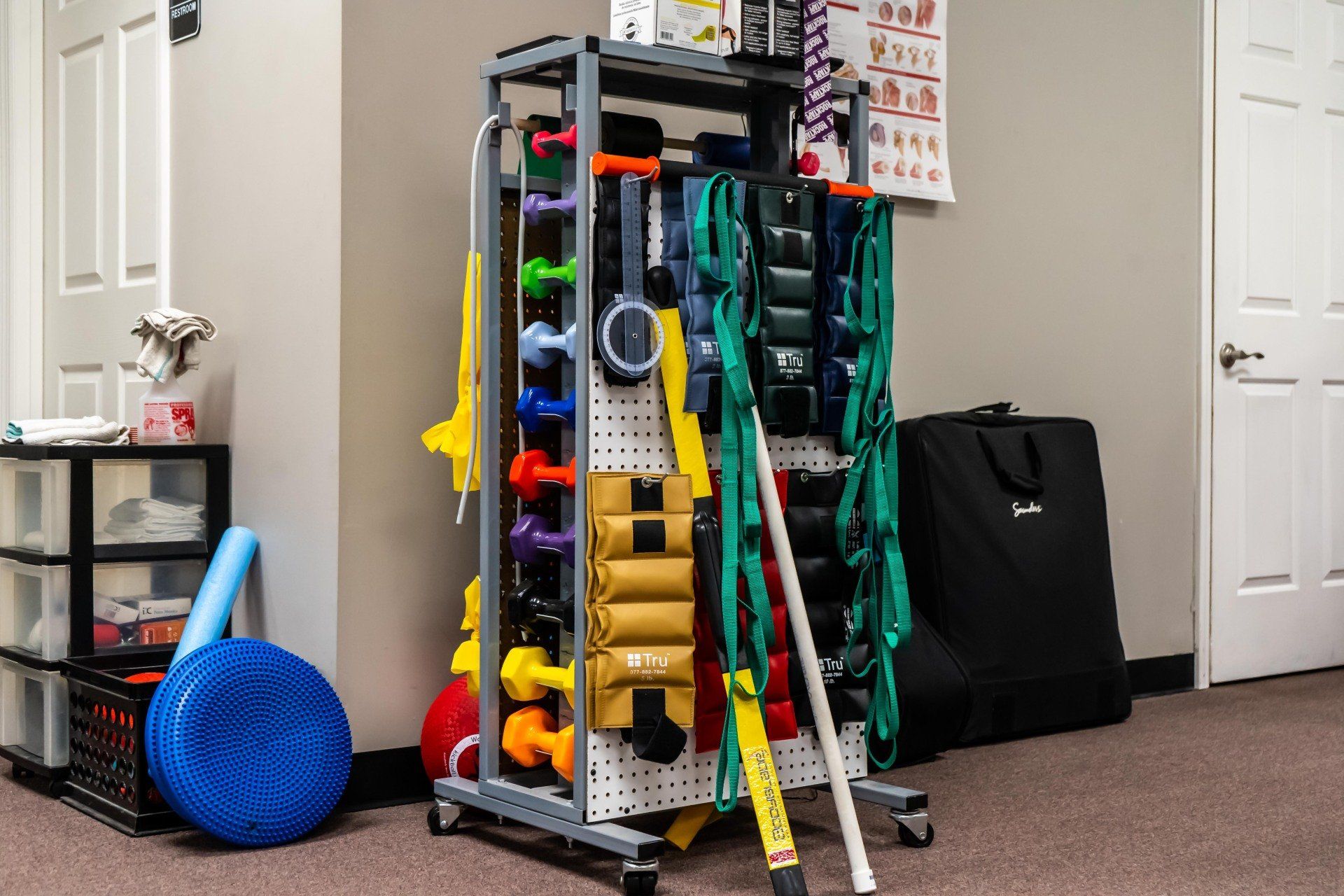 a rack filled with a variety of exercise equipment in a room .