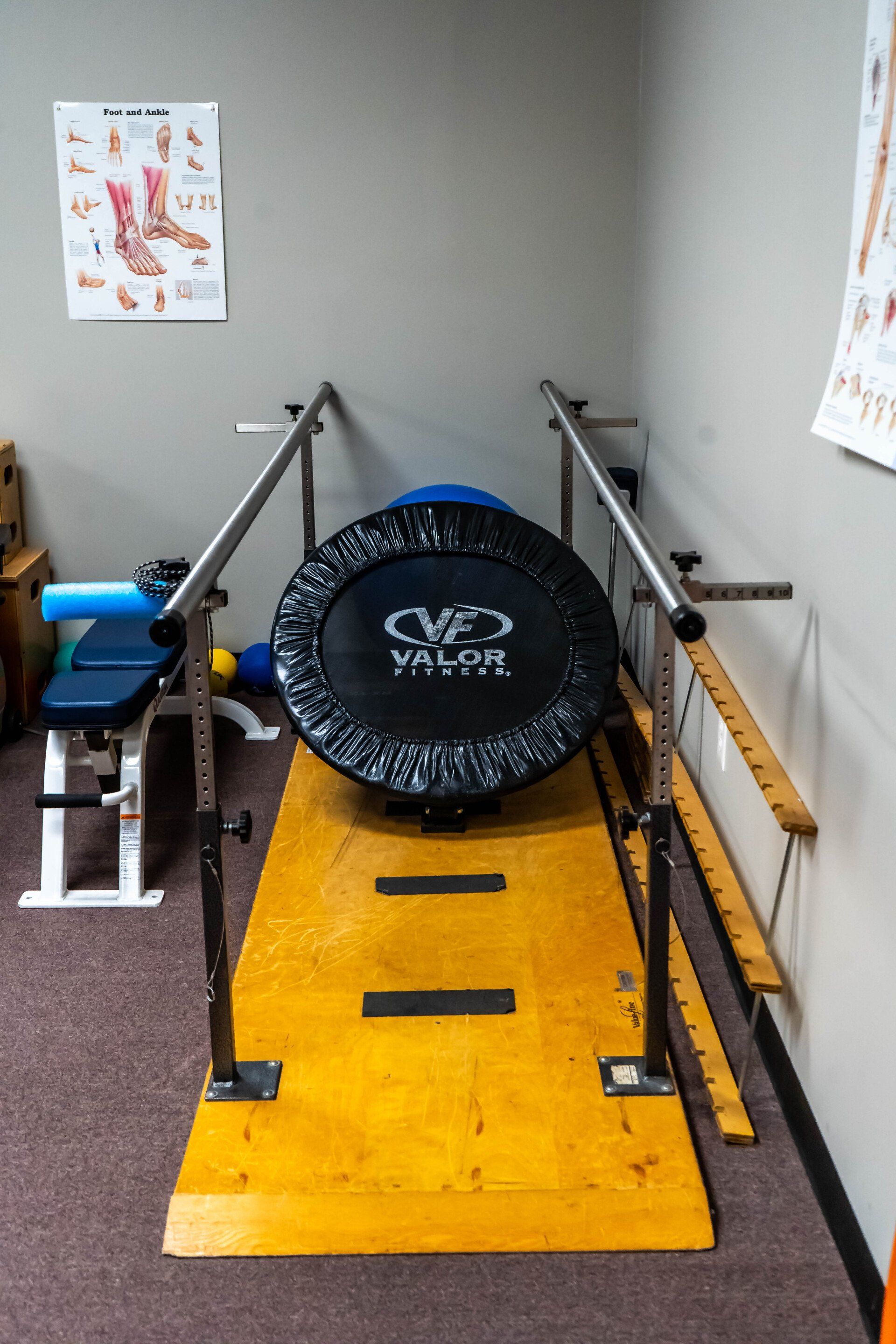 a gym with a trampoline and parallel bars