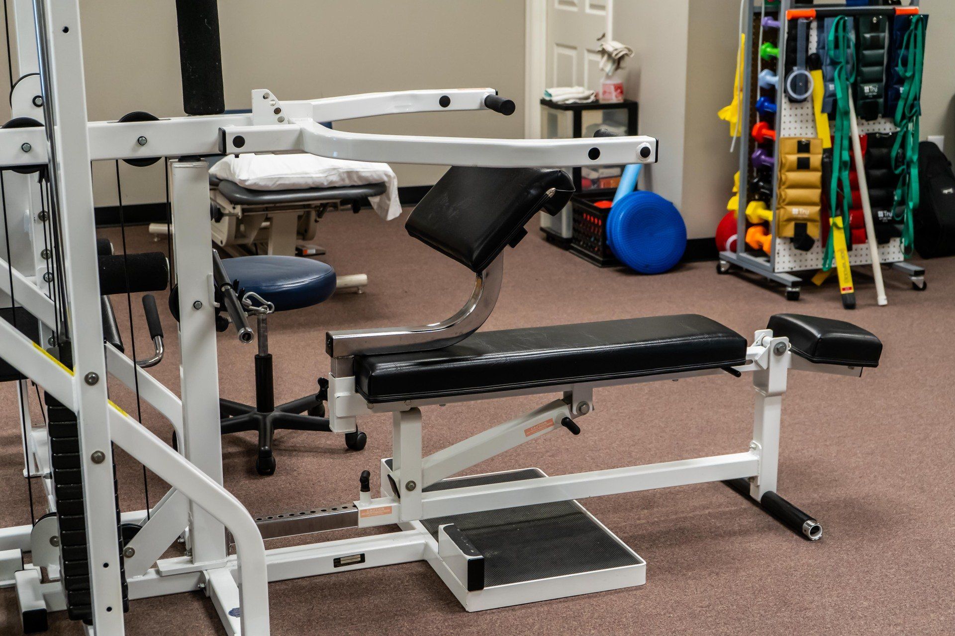 a gym with a bench and a row of dumbbells