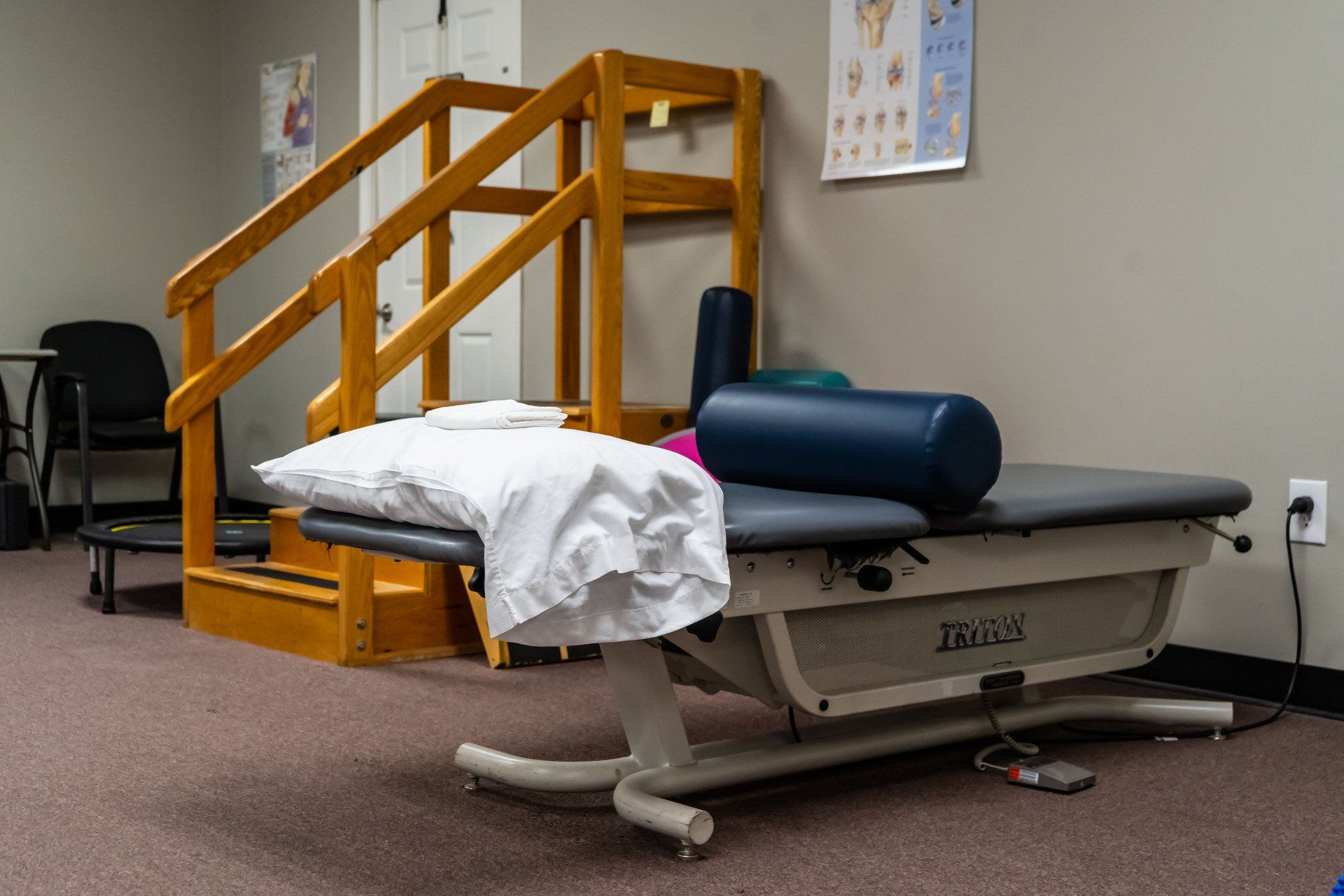 a physical therapy room with a table and stairs .
