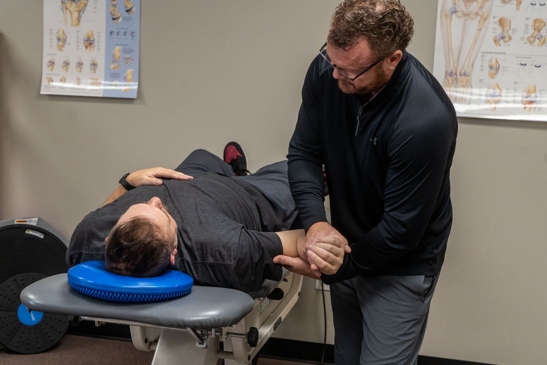 a man is laying on a table getting a massage from a physical therapist.
