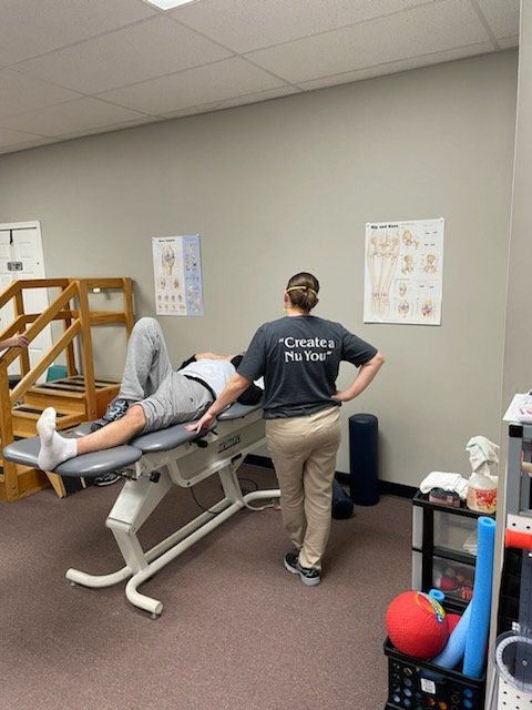 a man is laying on a table with a physical therapist standing behind him
