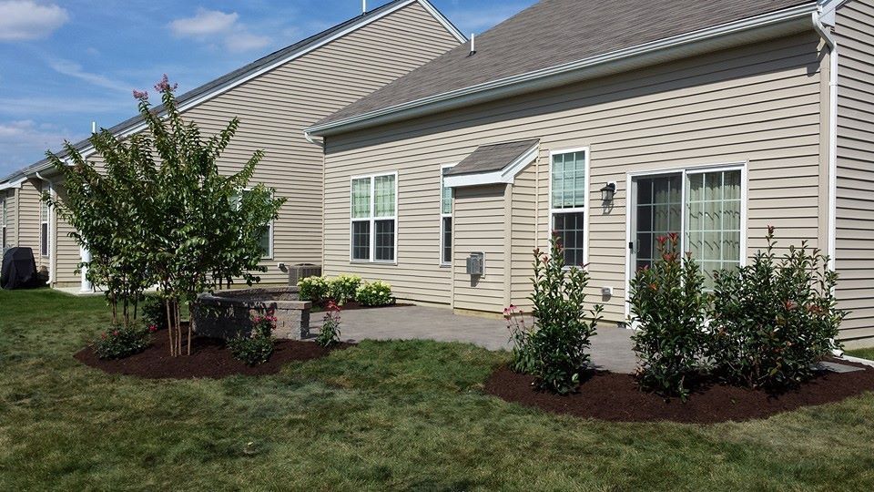 A house with a patio and trees in front of it.