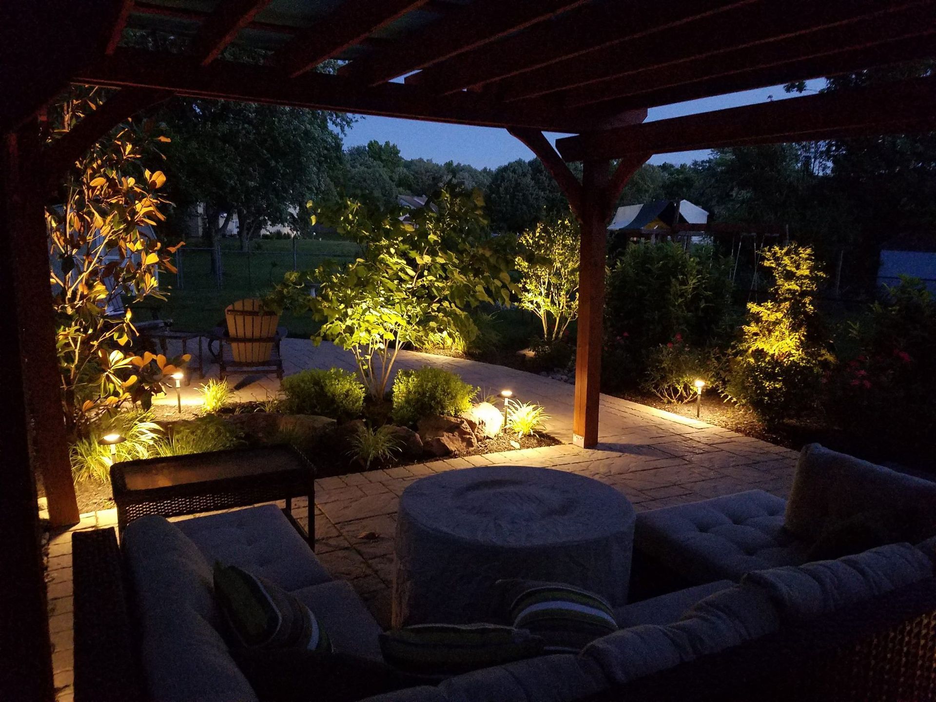 A patio area is lit up at night with a pergola