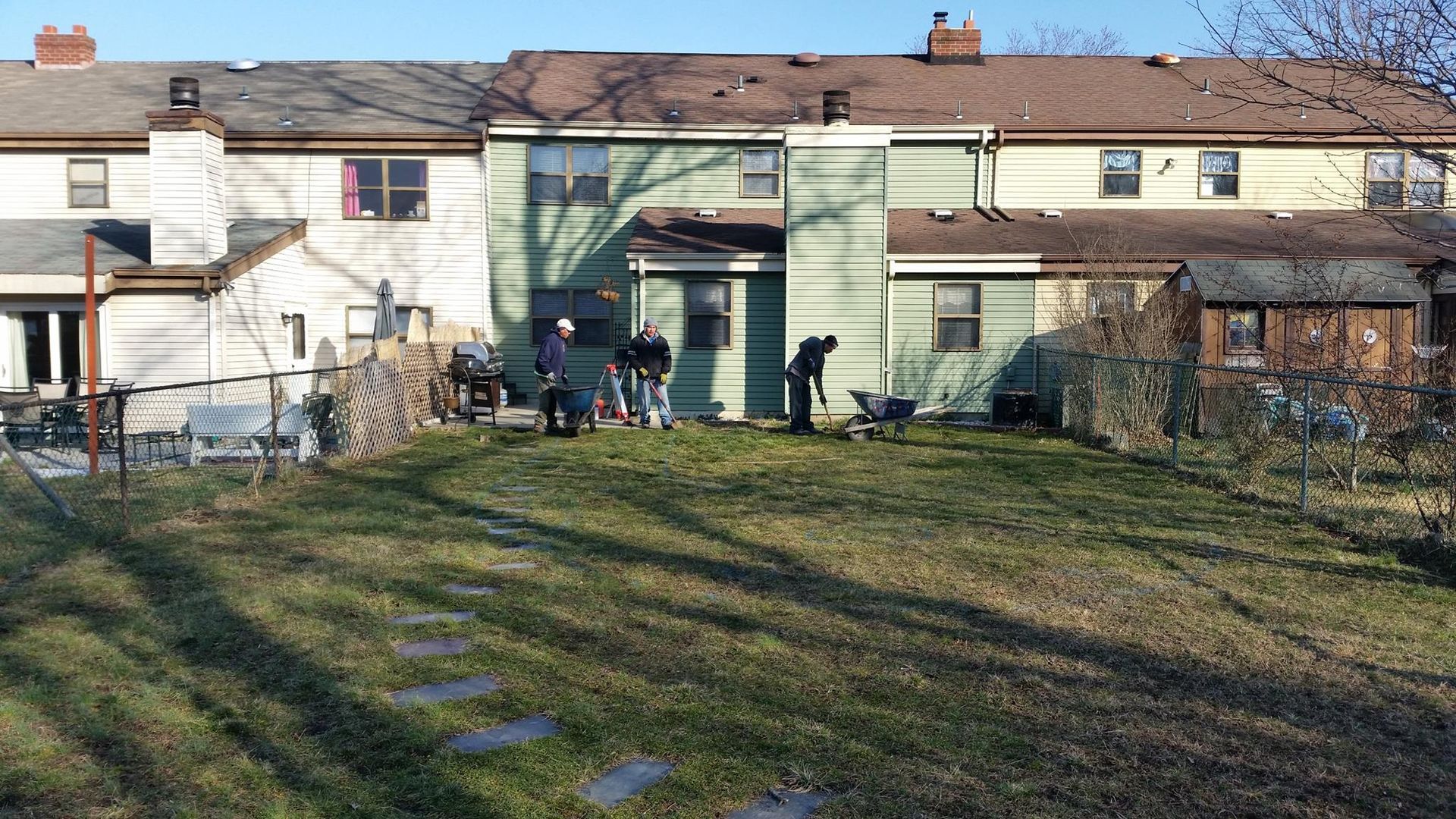 A group of people are standing in front of a house