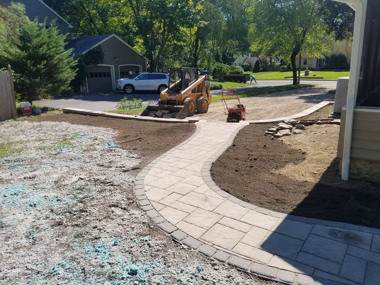 A walkway is being built in the backyard of a house.