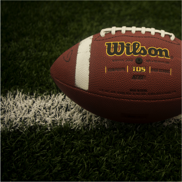 a wilson football is sitting on a field