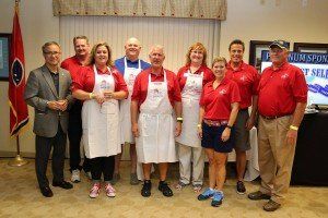 A group of people wearing aprons are posing for a picture