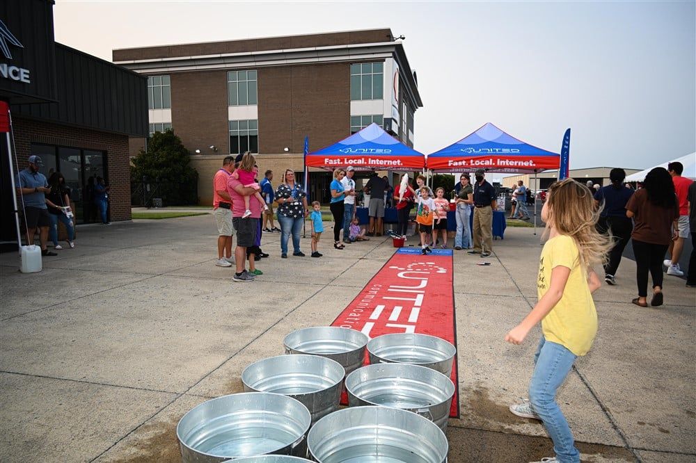 A little girl is playing a game with buckets of water.