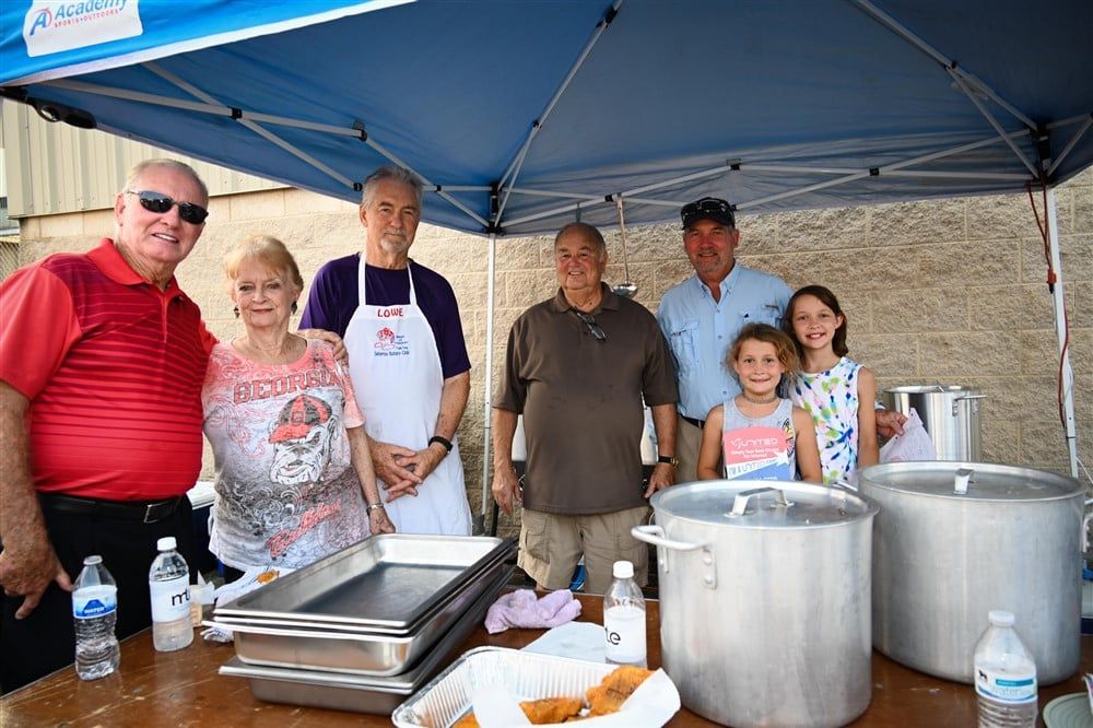 A group of people are posing for a picture under a tent.