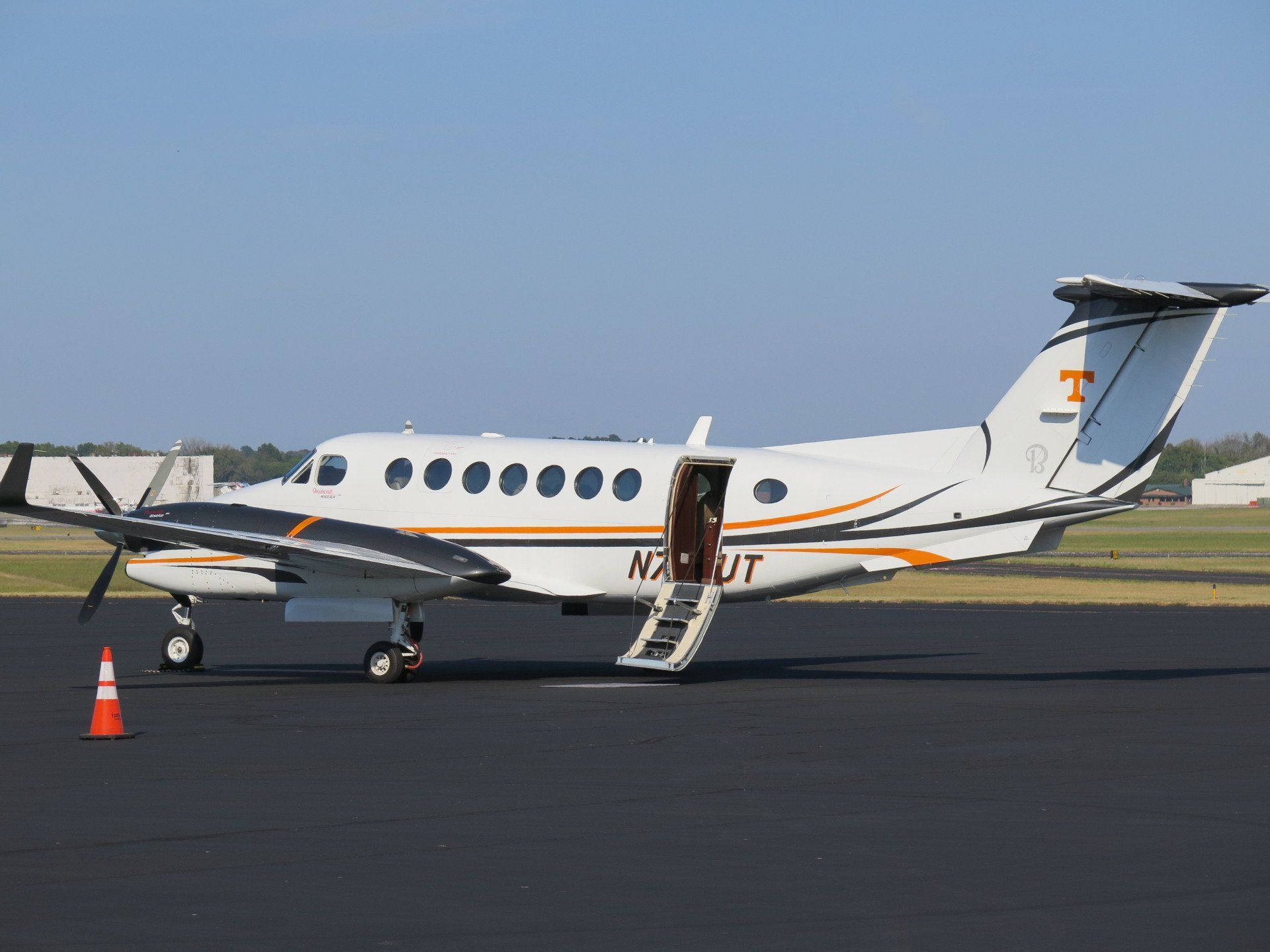 A small airplane with the letters nault on the side is parked on a runway.