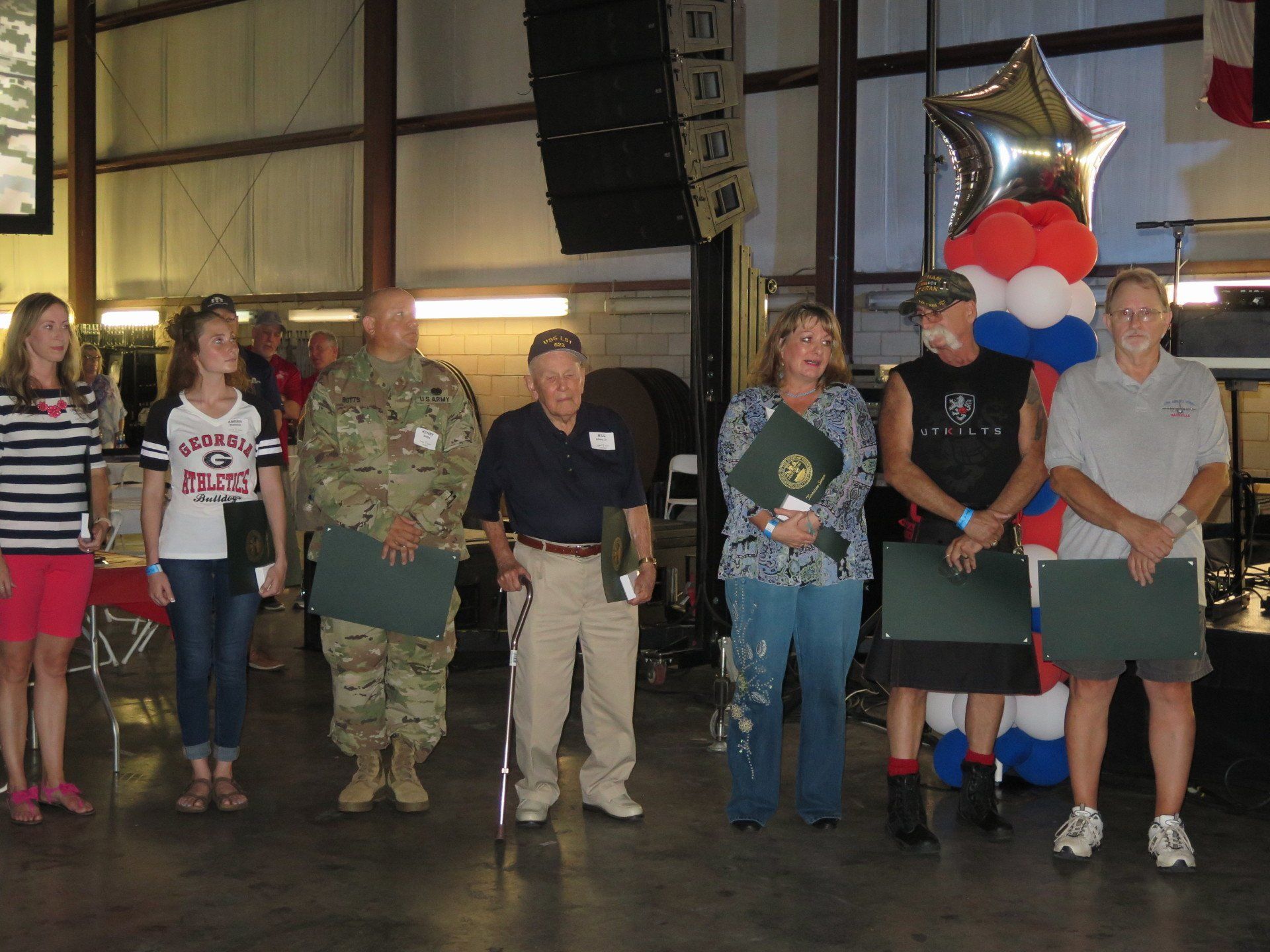 A group of people standing next to each other with balloons in the background