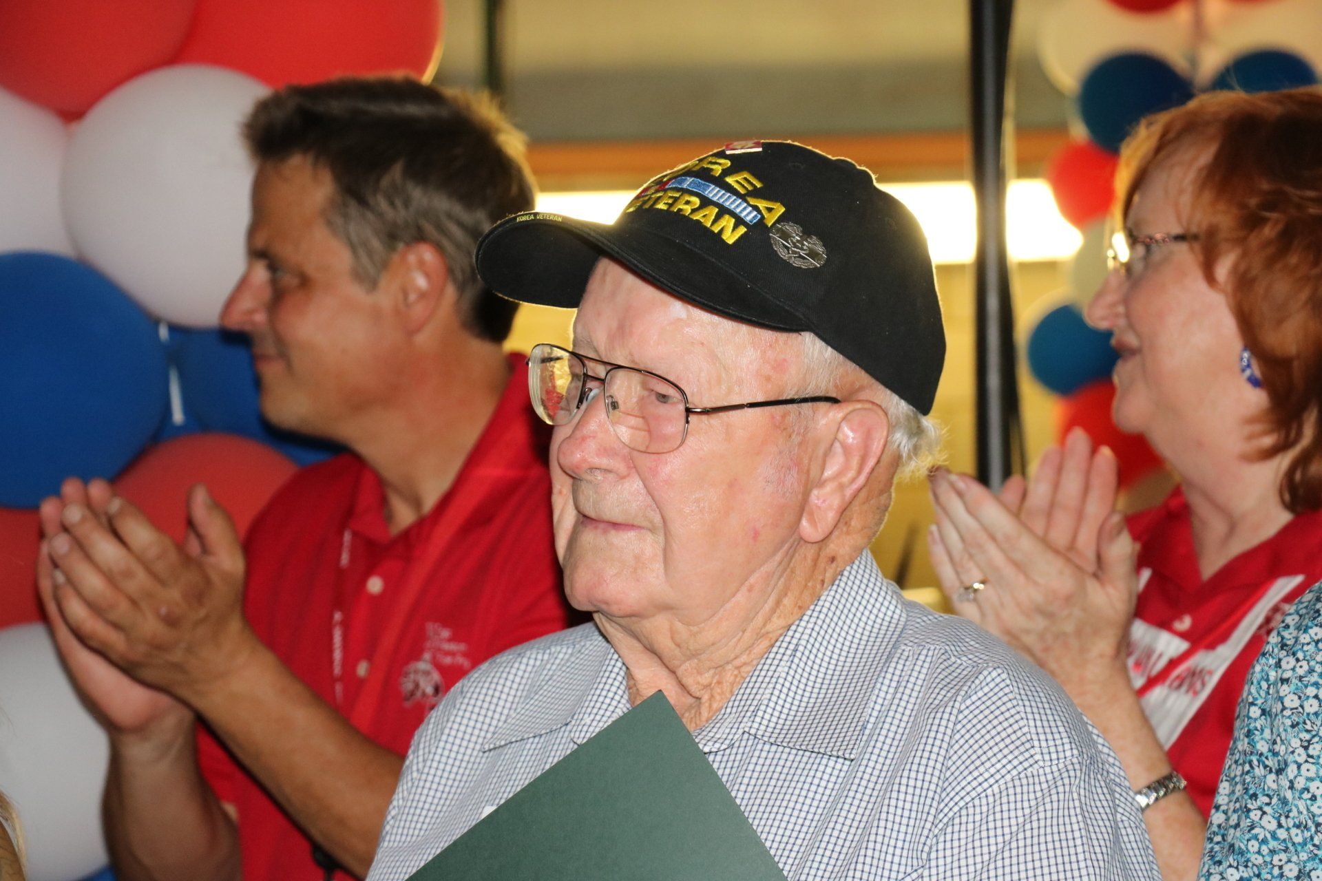A man wearing a black hat with the word veteran on it