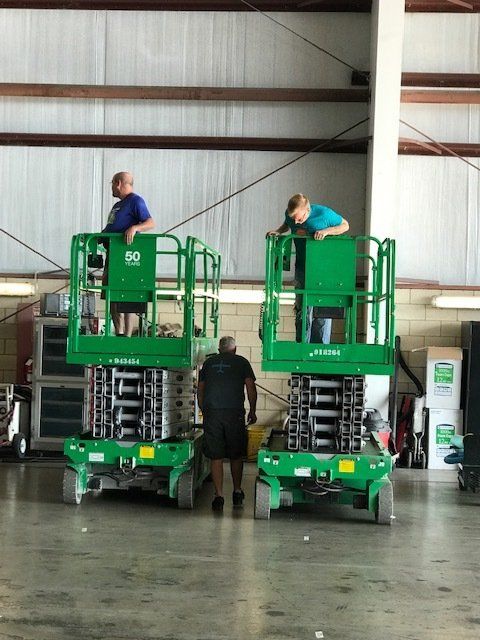 A man standing on a lift with the number 32 on it