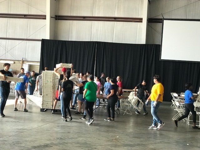 A group of people are standing in a large room.