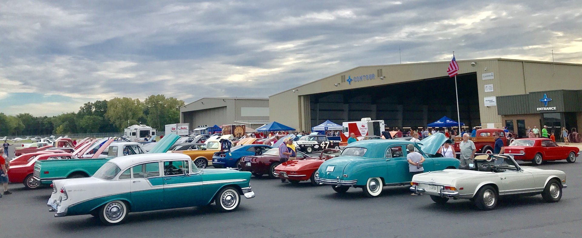 A lot of old cars are parked in front of a building