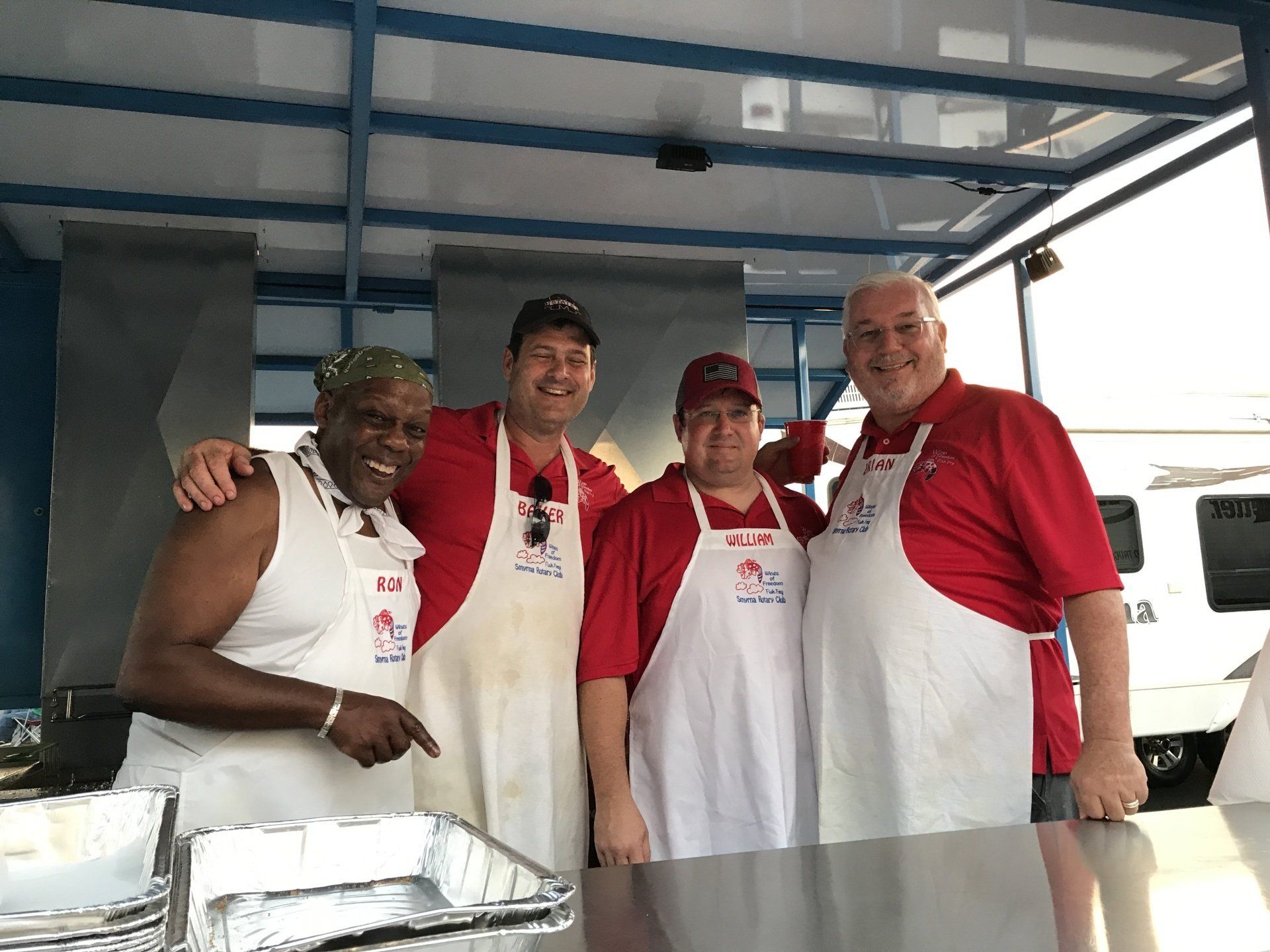 A group of men wearing aprons are posing for a picture.