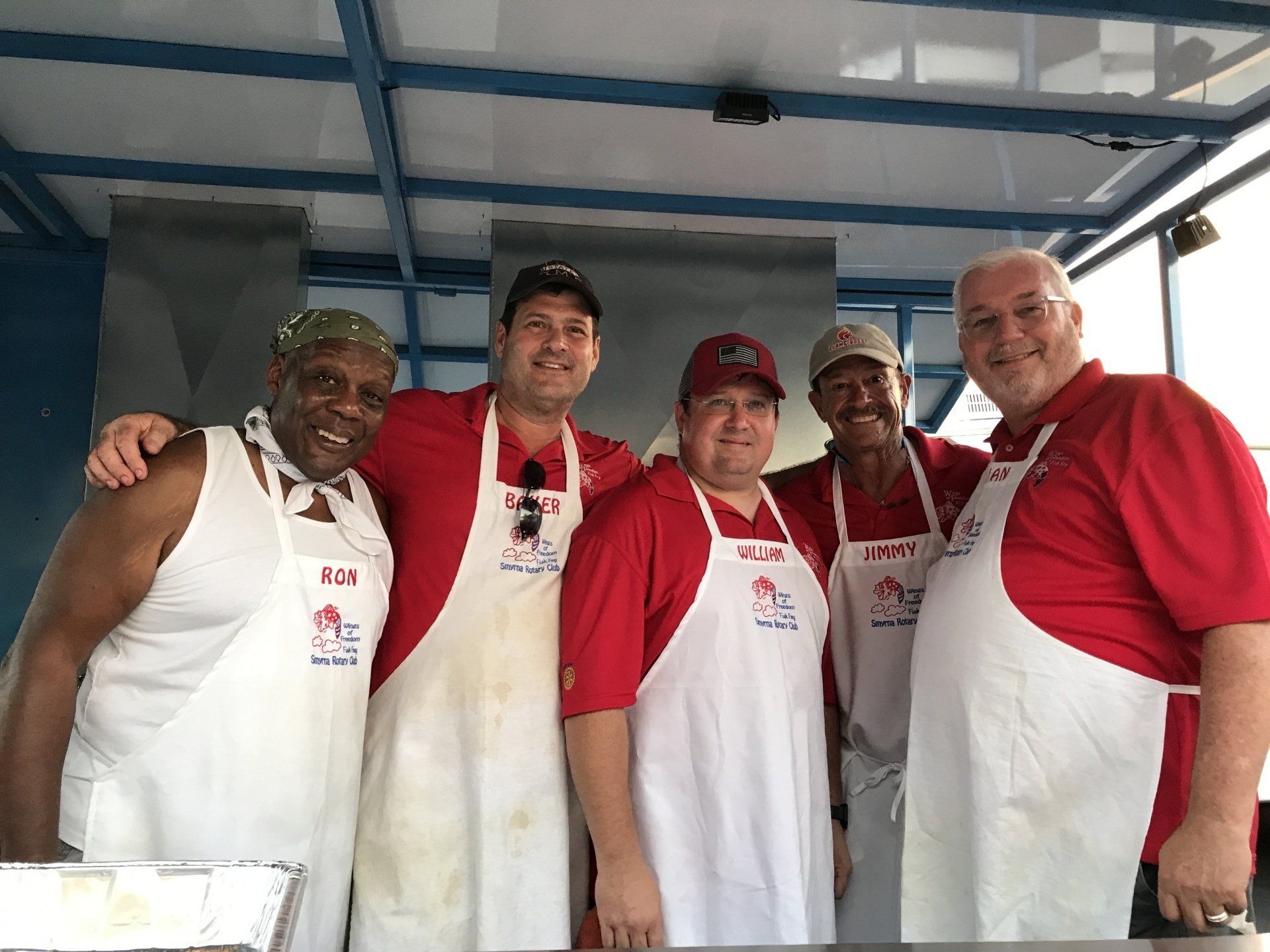A group of men wearing aprons are posing for a picture.