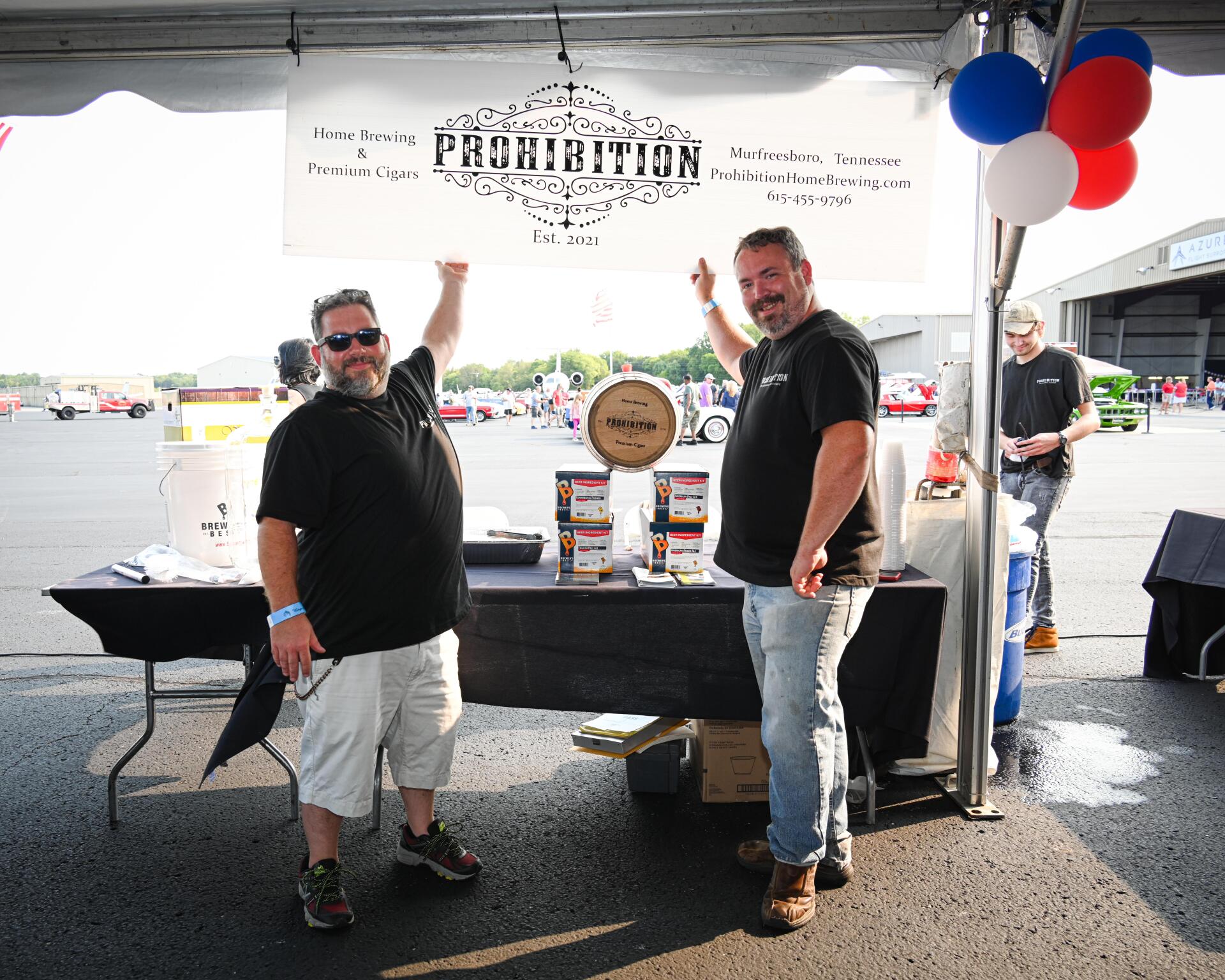 Two men standing in front of a sign that says provision