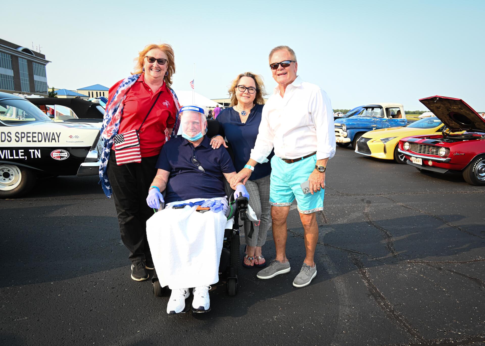 A group of people are posing for a picture with a man in a wheelchair.