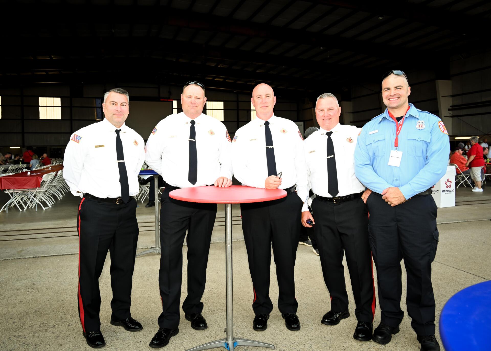 A group of men standing around a small table