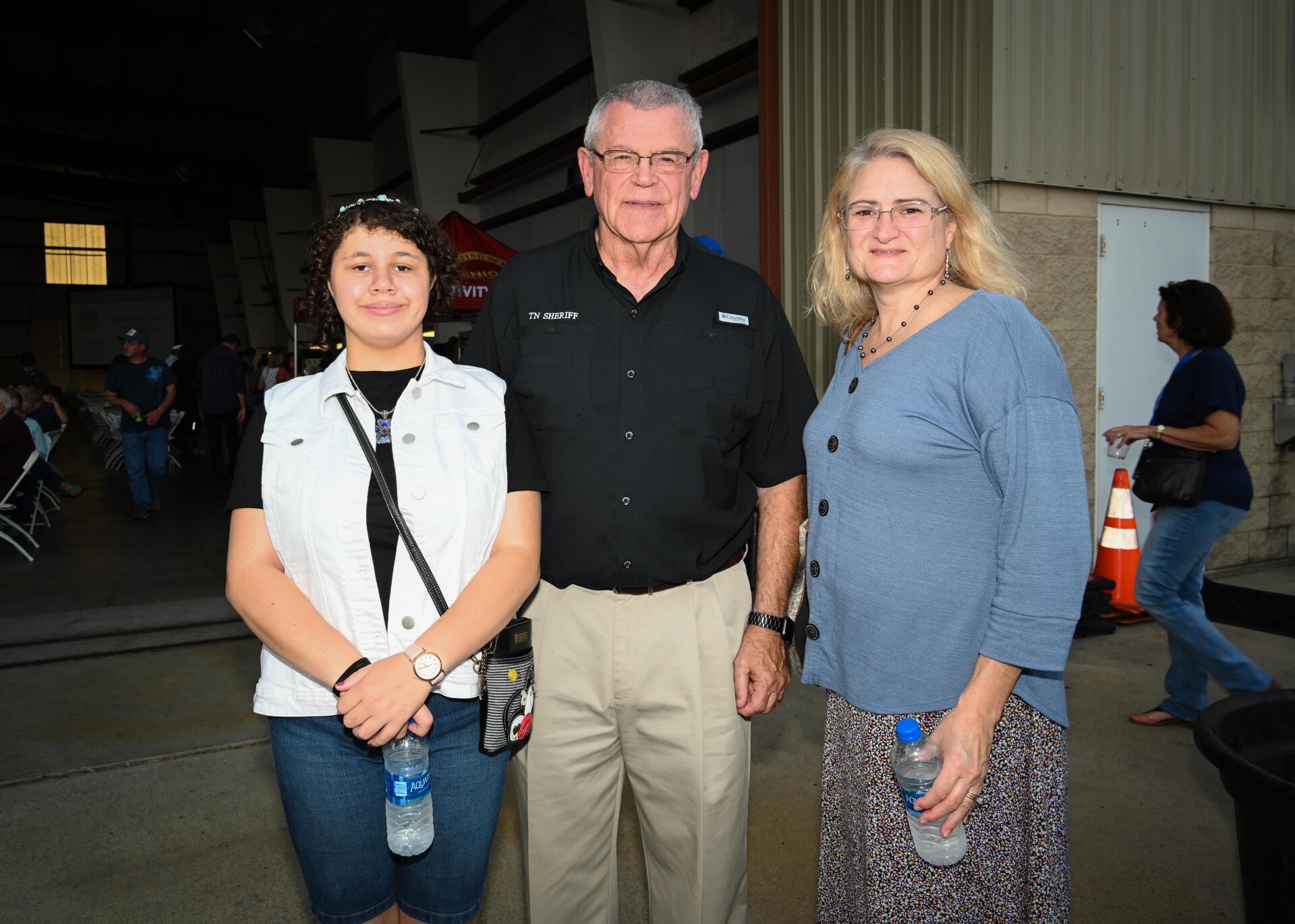 A man and two women are standing next to each other