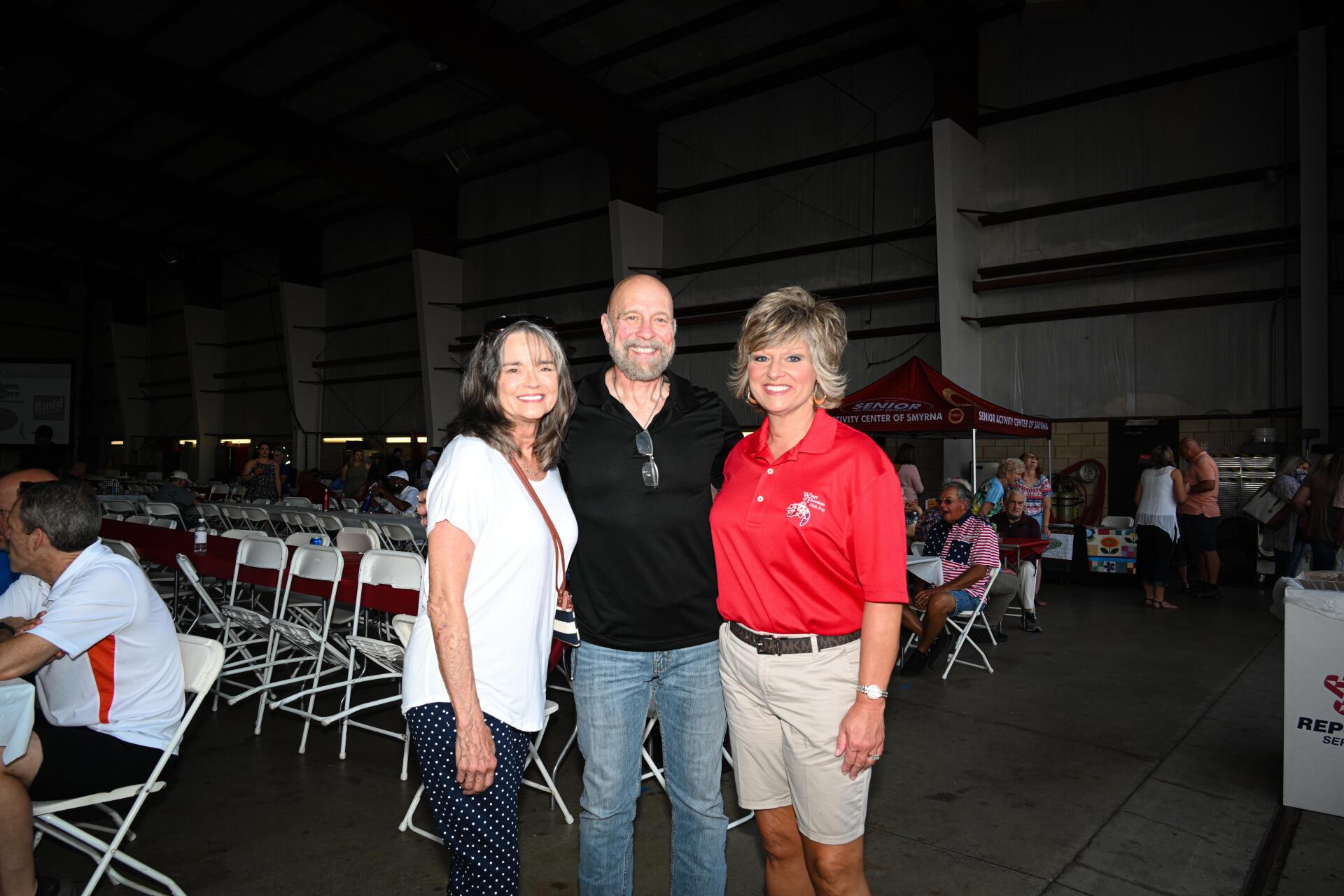 A man and two women are posing for a picture at a party.