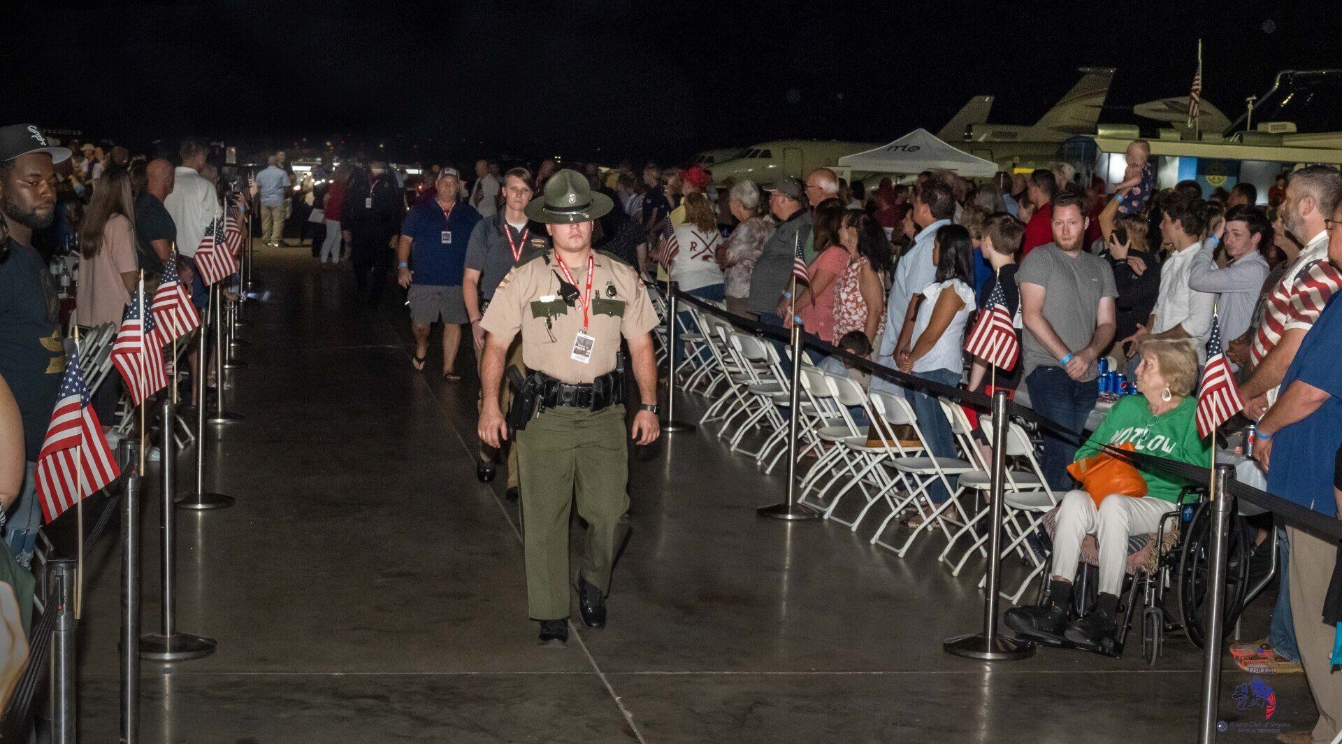 A man in a sheriff 's uniform is walking through a crowd of people.