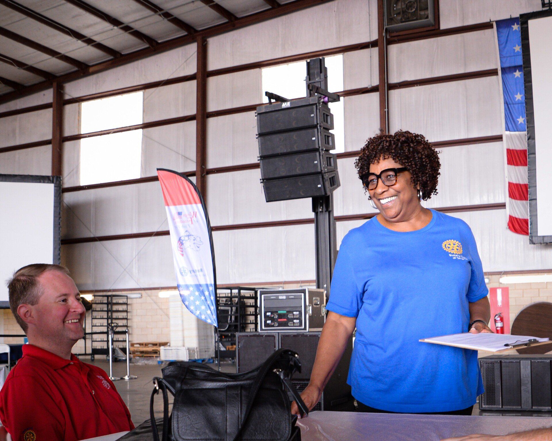 A woman in a blue shirt is standing next to a man in a red shirt.