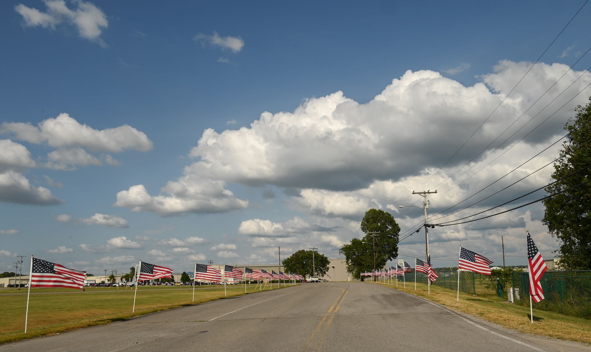 A row of american flags along the side of a road
