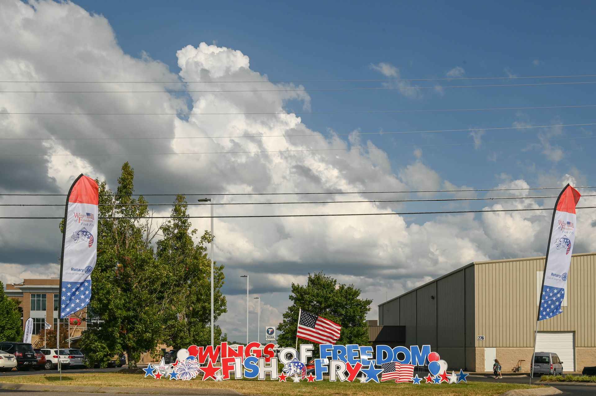 A sign that says freedom is surrounded by flags and balloons.