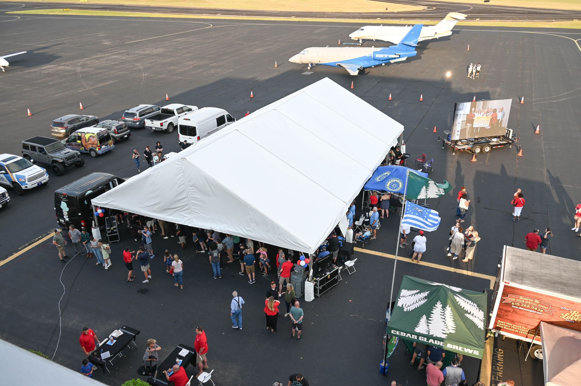 A group of people are gathered under a tent at an airport