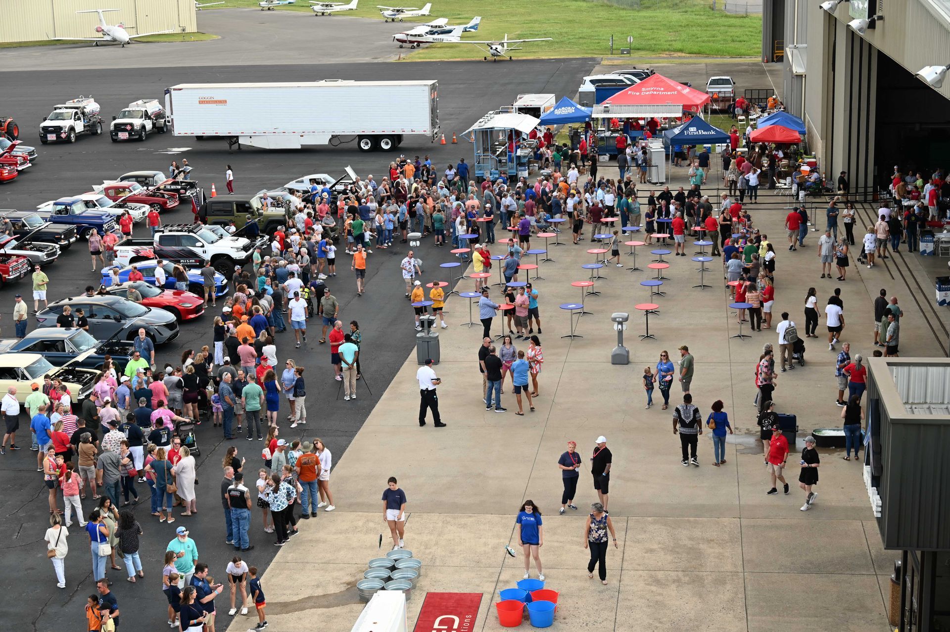 A large crowd of people are gathered in a parking lot