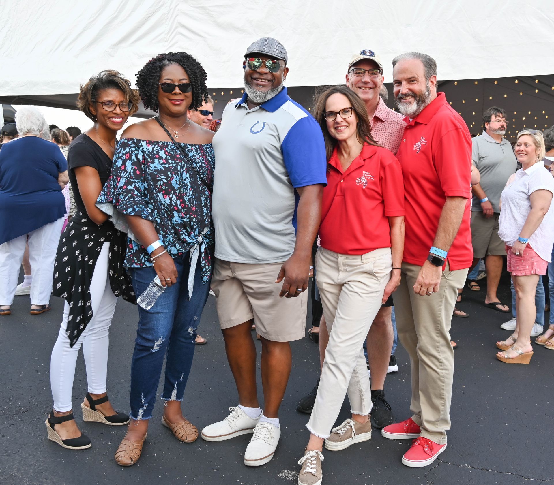 A group of people are posing for a picture in front of a tent.