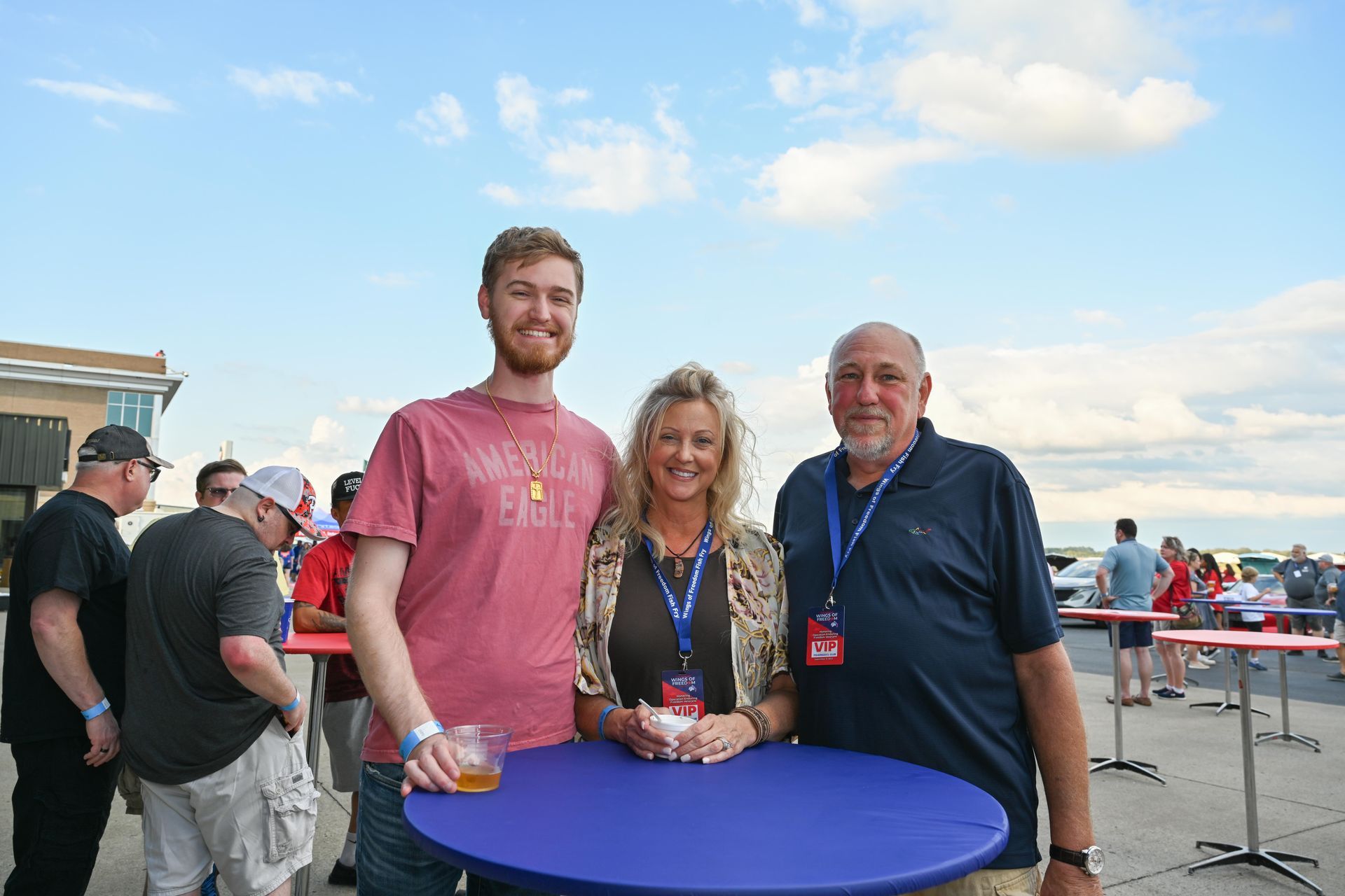 A group of people are standing around a blue table.